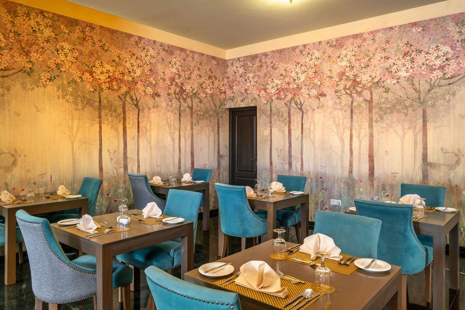 Dining room wrapped in a hand-painted forest mural