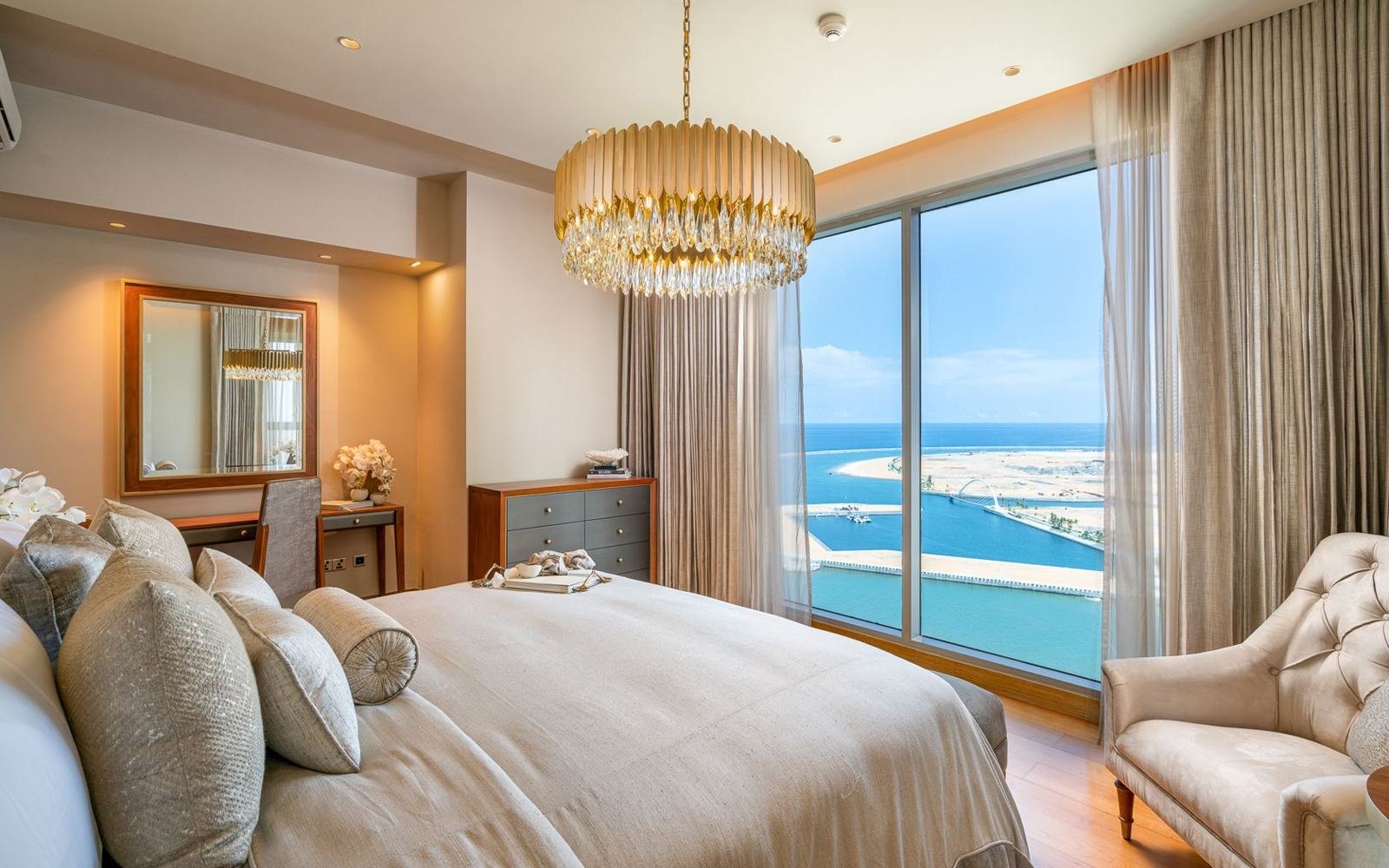 Bedroom with layered crystal lighting and full-height sheers